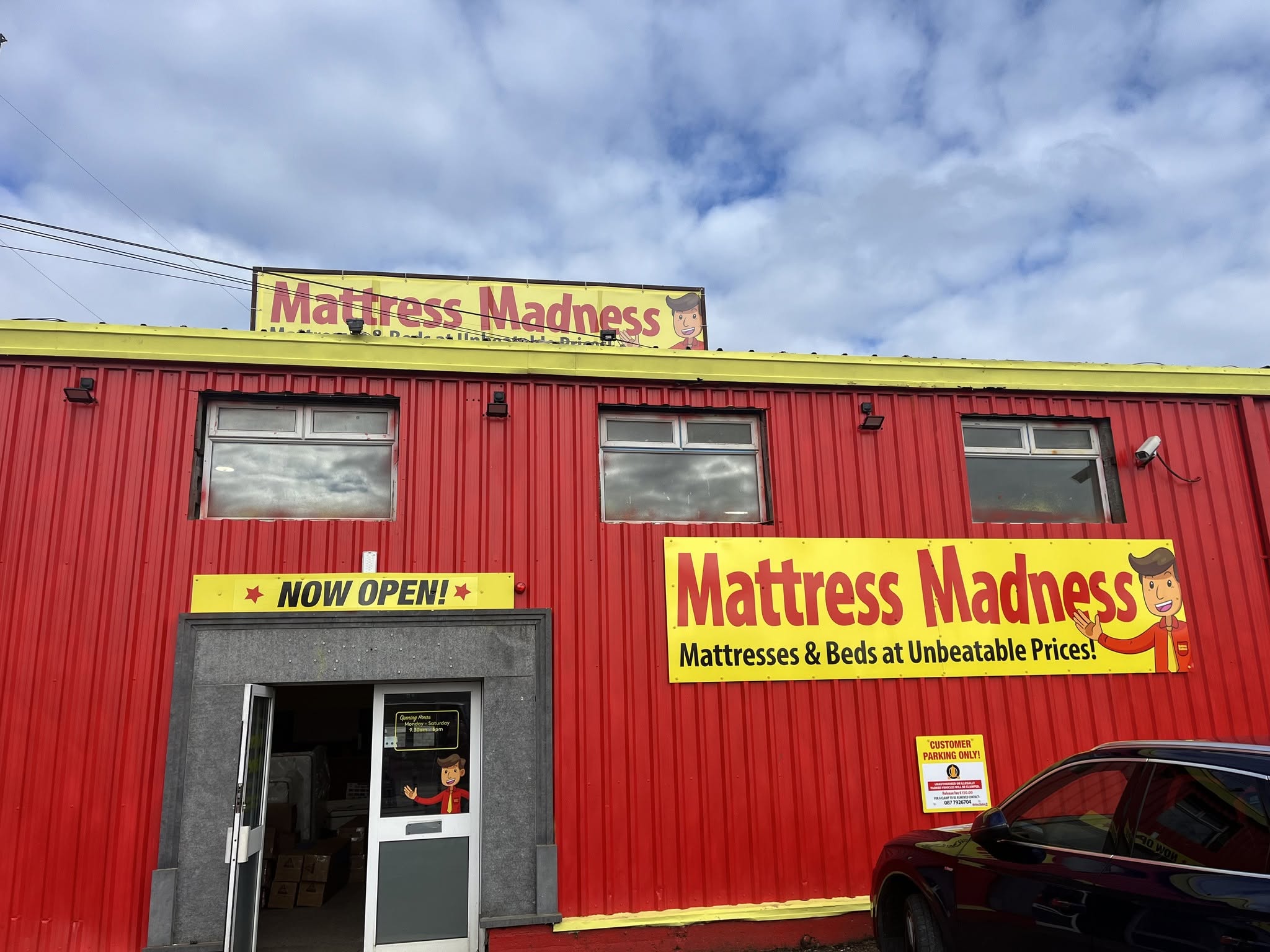 The Mattress Madness store on the Dublin Road, Portlaoise — a red building with 'Now Open' and Mattress Madness banners